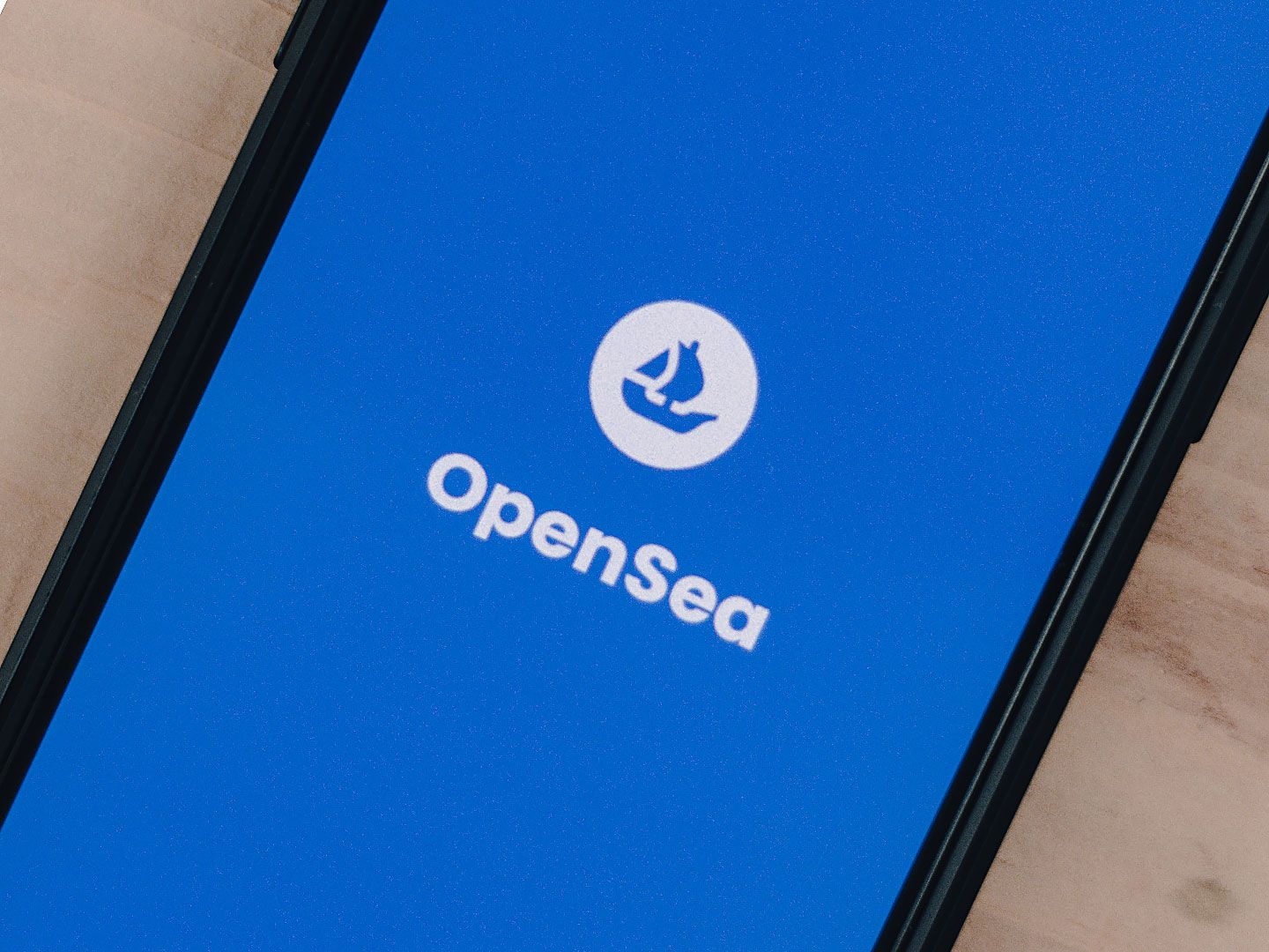 OpenSea logo on phone (Unsplash)